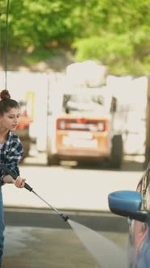 The Car Wash Scene Features a Charming Girl Using a Highpressure Water Gun to Wash a Car