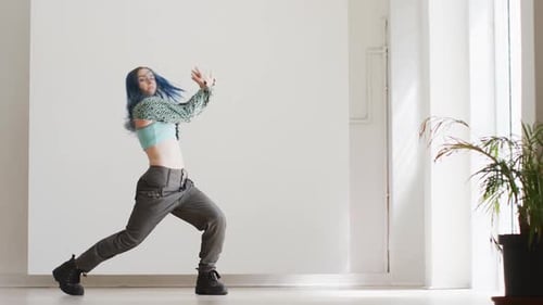 Portrait of caucasian female dancer dancing alone in dance studio, slow motion
