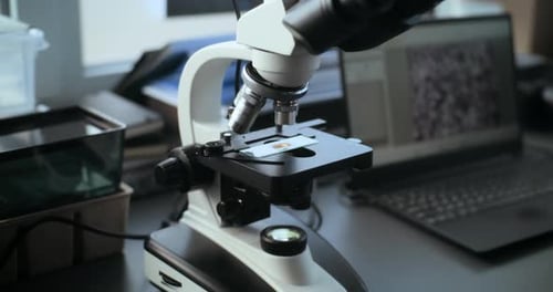 Microscope in a Lab with Laptop Background