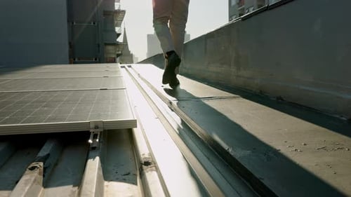 Rooftop Worker Inspecting Solar Panels in the City