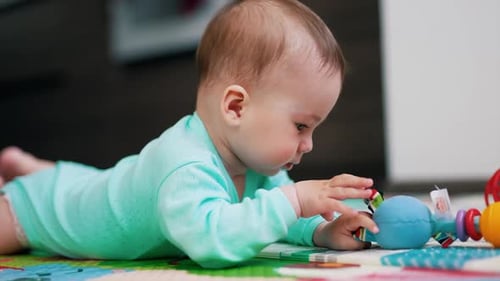 Baby Lying on Stomach Playing with Toy