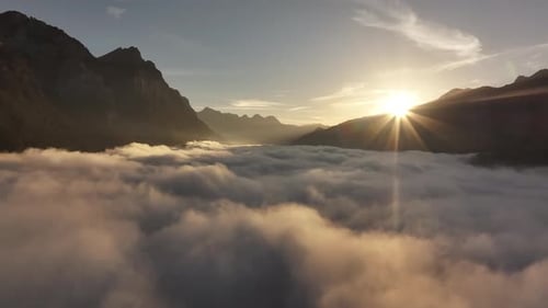 Golden sunrise over a valley with clouds and mountain peaks in Switzerland, serene and peaceful