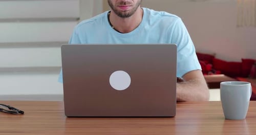Young Adult Opens Laptop and Drinks