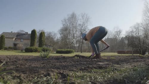 Woman Prepares Soil in a Rural Garden
