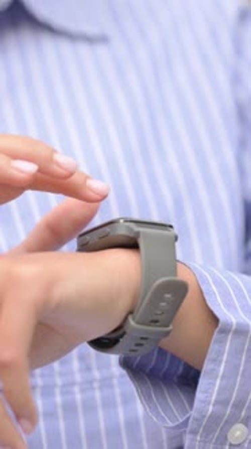 Close up of Hispanic Woman Browsing Internet Smart Watch Outdoor, vertical