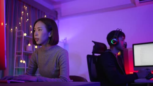 Man and Woman Working at Computers at Night