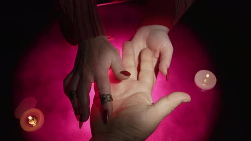 Palmistry, fortune teller reading line on male palm of hand close-up, top view