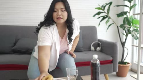Plus size woman is eating junk food.