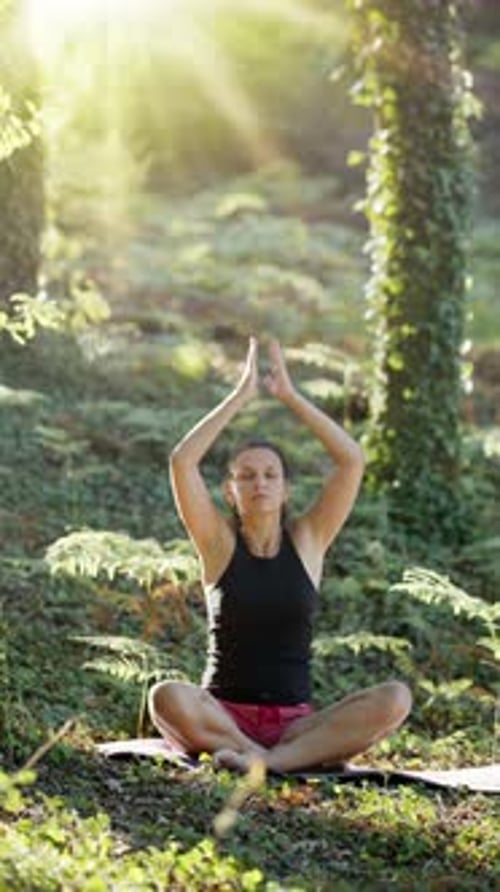 Woman Practicing Yoga in Forest Sunlight