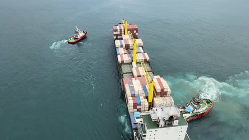 Container Ship Towed by Tugboats in Open Water