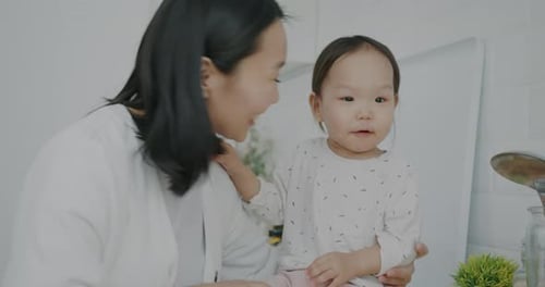 Adorable Little Child Laughing Clapping Hands Having Fun While Mother Kissing Daughter Expressing