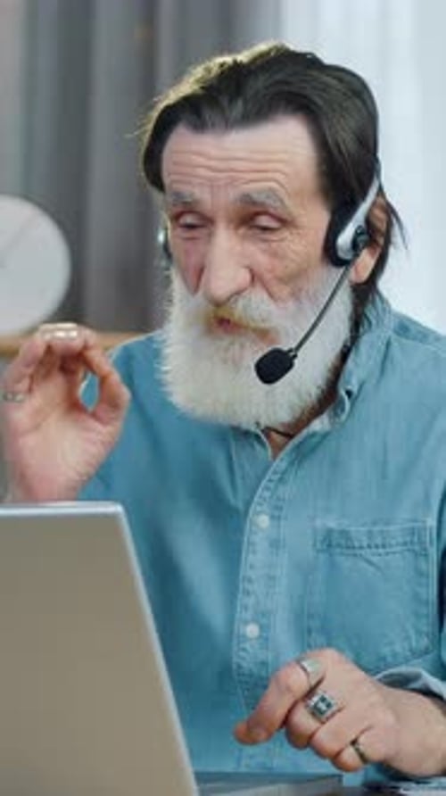 Senior Man Video Call with Headset and Laptop
