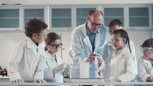 Teacher Guiding Children in Science Experiment in Lab