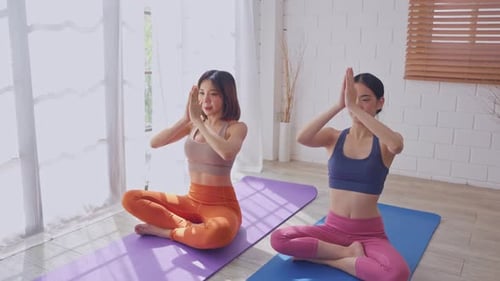 Young Women Doing Yoga on Mats Indoors