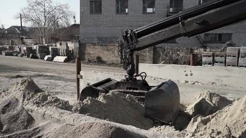 Riesiger schwarzer Eimer, schnappt sich Sand und bringt ihn in einen großen Sandhangar