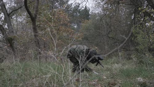 Männlicher Paintball schießt im Sprung