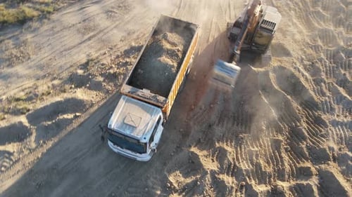 Excavator Loads Soil Into Dump Truck, Aerial View
