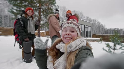 Cheerful family smiling in winter snow selfie