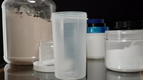 Protein Powder being poured into an empty shaker bottle, setting up for the next post-workout