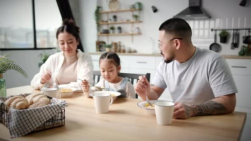 Family Eating Cereal Together at Kitchen Table