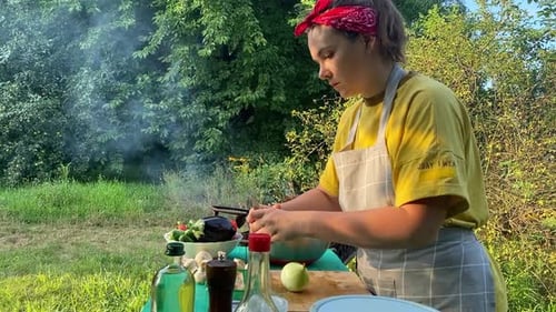 Woman Cooks Vegetables at Outdoor Kitchen