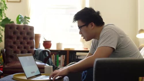 Young Man Working on Laptop at Home