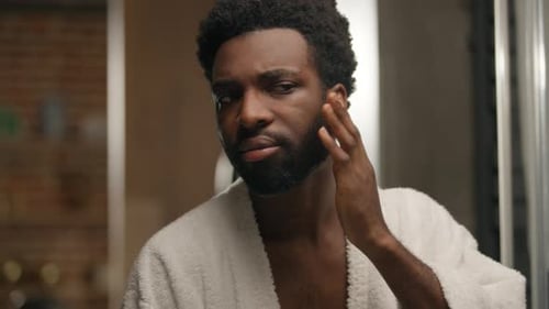African American Man Looking at Mirror Reflection Hotel Bathroom Smiling Bearded Guy Shaving Beard