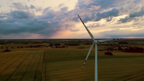 Large Wind Turbines with Spinning Blades in Field Generating Renewable Electric Energy at Evening