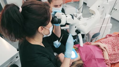 Dentist Using Microscope During Dental Exam Procedure