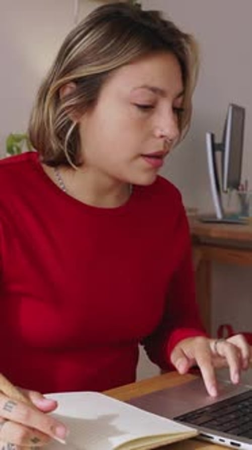 Woman Studies and Writes in Notebook Indoors