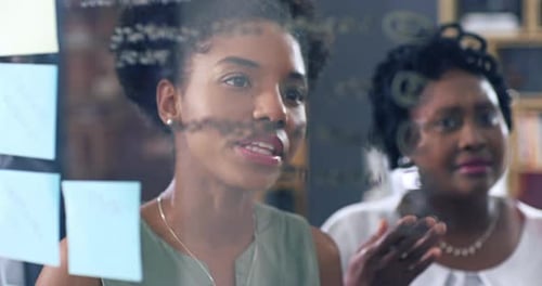 Team Collaboration on Glass Wall in Modern Office