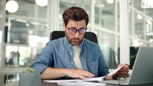 Tired Exhausted Businessman Office Worker Sits at His Desk Reading Documents