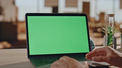 Typing on Laptop with Green Screen in Office