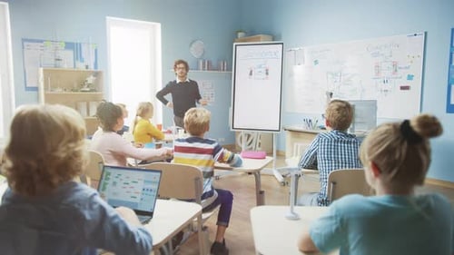 Elementary School Physics Teacher Uses Interactive Digital Whiteboard to Show to a Classroom full o