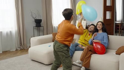 Boy Plays with Balloons at Home Birthday Celebration