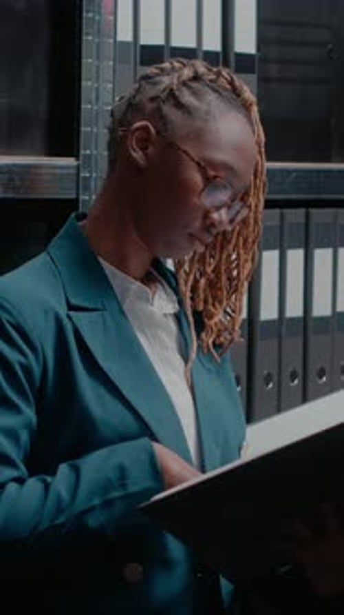 Woman Reading Business Records in Filing Room