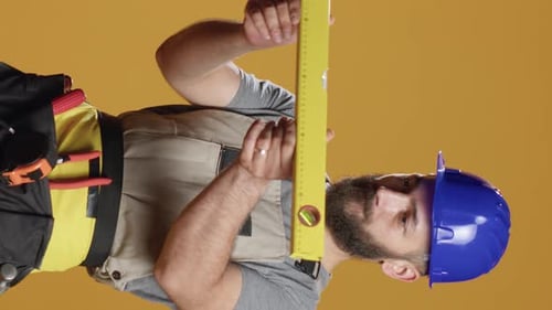Vertical Video Construction Builder Working with Water Level Tool to Do Measurement