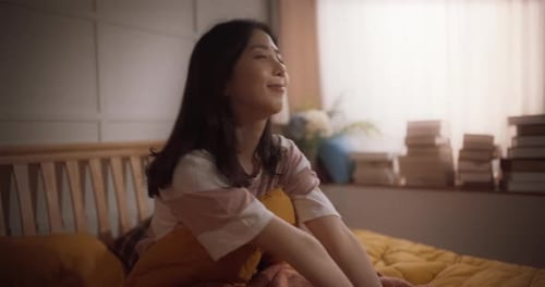 Woman Stretching and Smiling in Bedroom Morning Light
