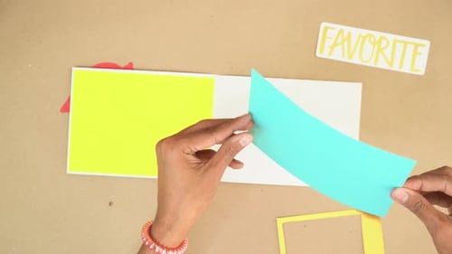 Hands Crafting a Colorful Scrapbook Page