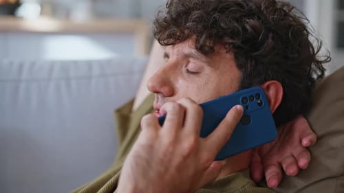 Man Talking on Cellphone Lying on Couch