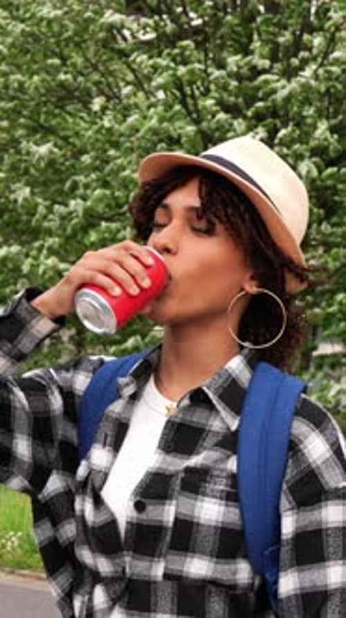 Young Latina Student Drinking Soda in Slow Motion