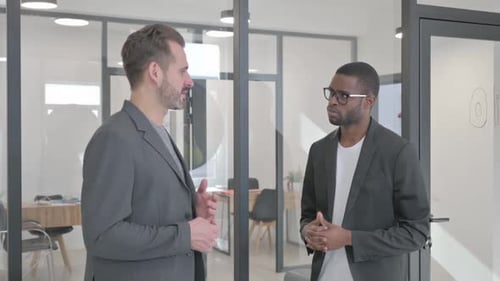 Mixed Race Entrepreneurs Discussing Business while Standing in Office