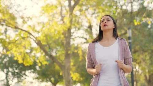 Young Woman Jogging in Urban Park on Sunny Day