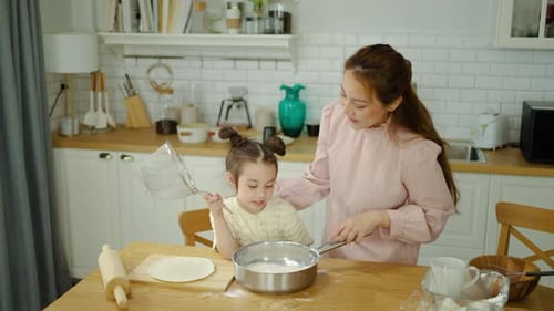 Woman and Girl Baking Together in Bright Kitchen