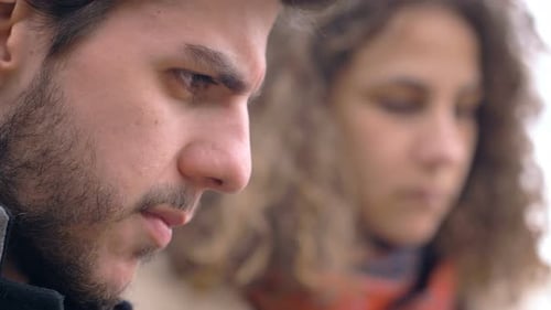 serious thoughtful couple looking down not talking to each other