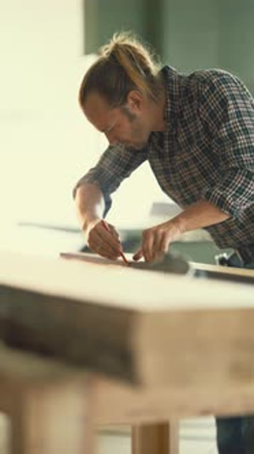 Professional Carpenter Measuring a Wooden Plank