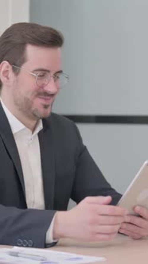 Man in Suit Using Tablet for Video Call