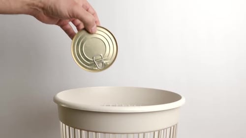 E66. Expired metal cans are thrown into the trash. Disposal of household waste.