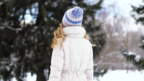 People, Season and Leisure Concept - Woman Walking in Winter Forest Or