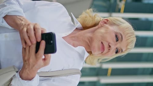 Aged Woman Smartphone Looking Around at Urban Street Closeup Vertically Video